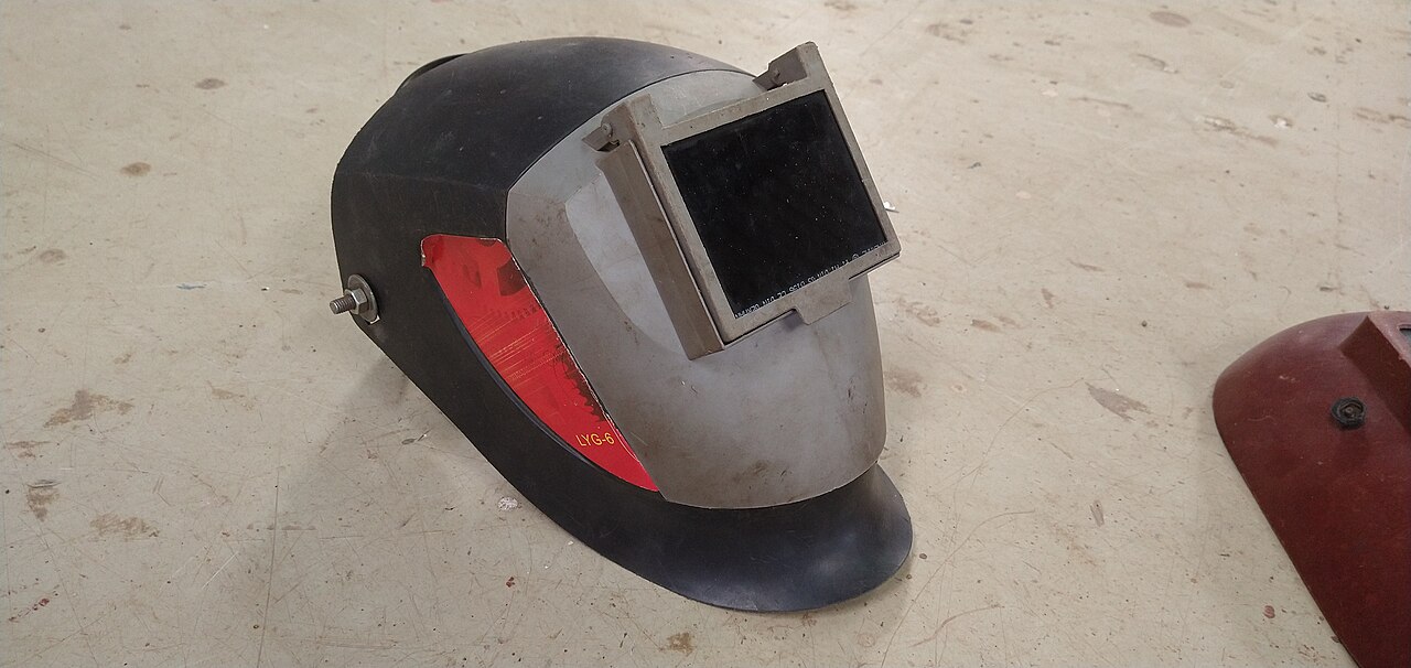 A welding helmet resting on a bench