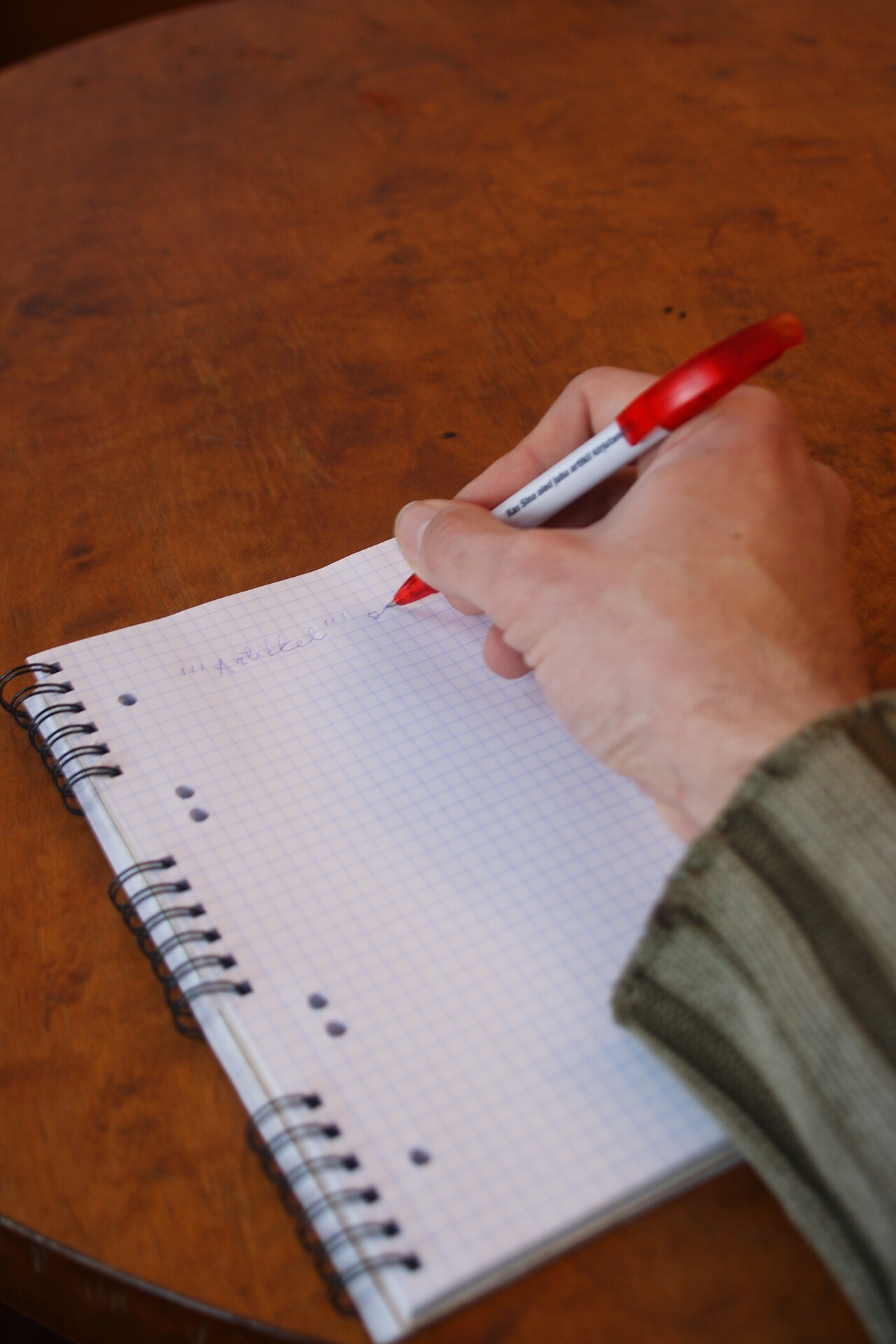 A hand writing notes in a notebook