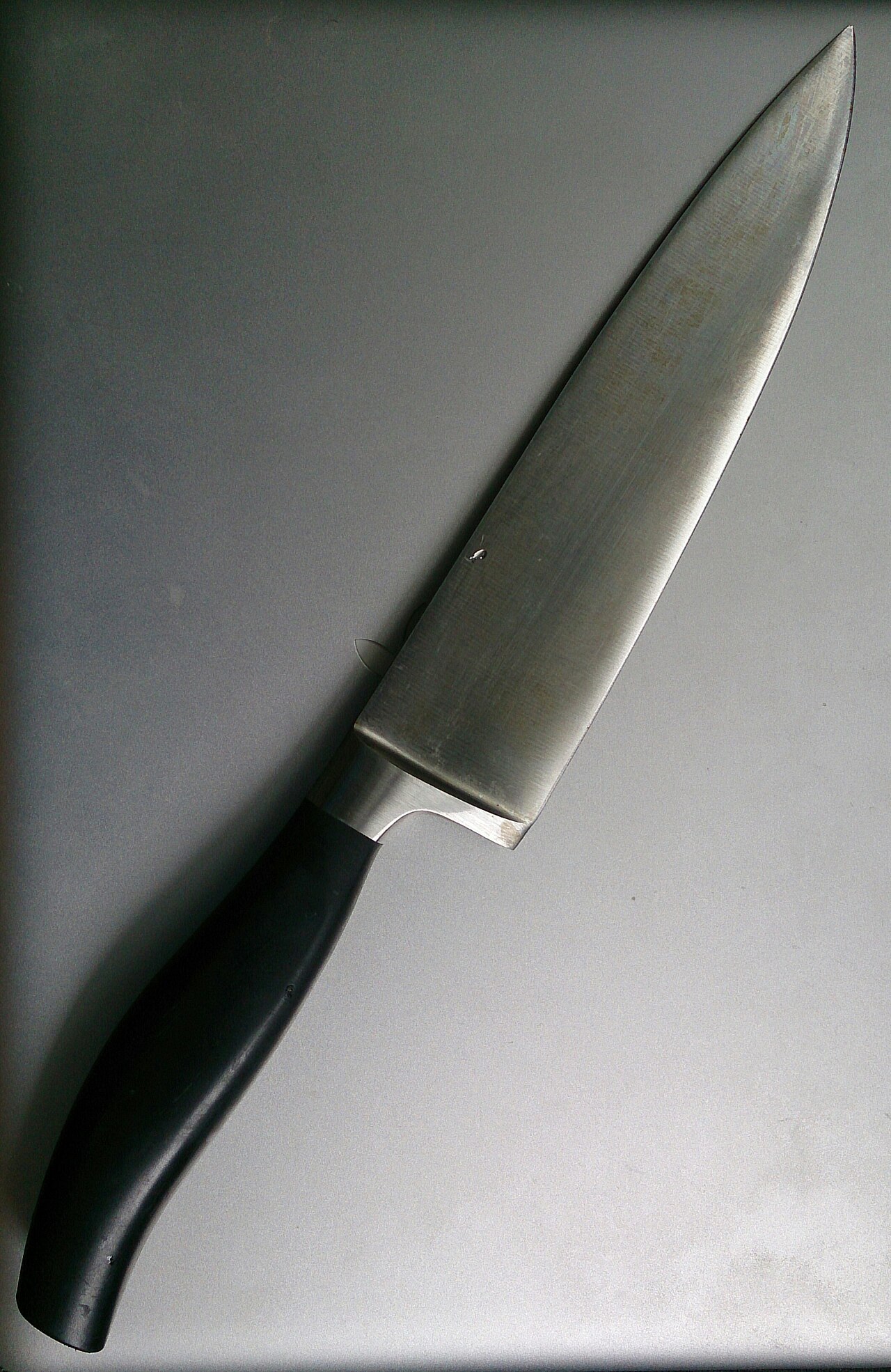 A chef's knife on a kitchen bench